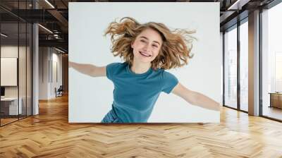 Carefree Young Woman Smiling Happily in the Air Wall mural