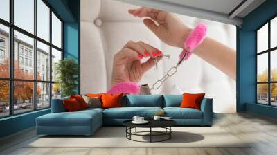 Pink sexy fluffy handcuff on female wrists Wall mural