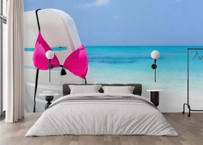 Swimsuit hanging on white chaise longue Wall mural