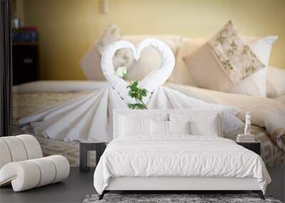 View of two white towels swans on bed sheet in hotel Wall mural