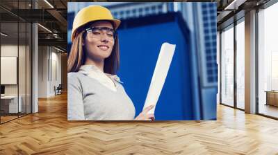 Beautiful woman civil engineer is posing for success in front of a building Wall mural