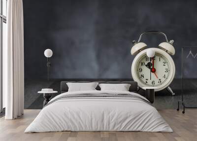 Clock hand at 10 o'clock alarm at 5 o'clock. Vintage / retro white analog alarm clock on wooden table with copy space on dark background Wall mural