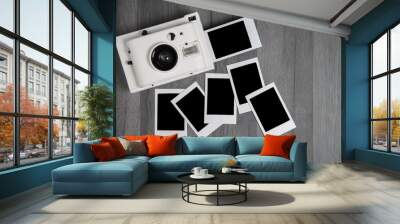 Vintage instant photo camera with blank polaroid photos with copy space on wooden table Wall mural