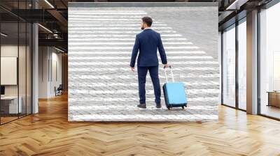 happy businessman with travel suitcase crossed signposted crossing of city street Wall mural