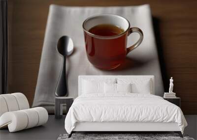 Glass cup of tea and a spoon on a piece of fabric cloth on a wooden table, restaurant and cafe photography Wall mural