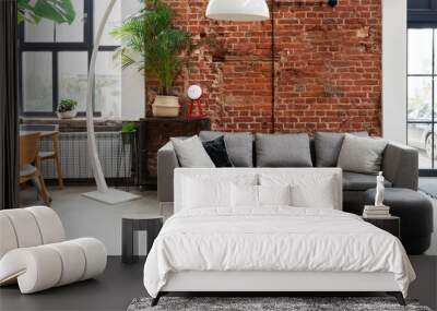 Industrial living room with sofa in loft apartment with window and brick wall. Spacious interior of room. Wall mural