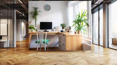 Interior of office room with big window, green plants, wooden furniture and computer with blank monitor with mock up. Light workspace with desk in vintage style. Home office. Banner. Wall mural