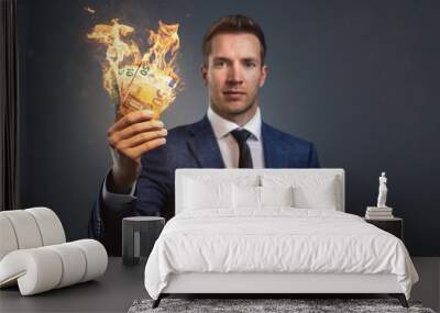 Businessman holding burning money in his hand Wall mural