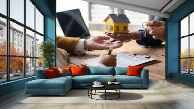 A home rental company employee is handing the house keys to a customer who has agreed to sign a rental contract, explaining the details and terms of the rental. Home and real estate rental ideas. Wall mural