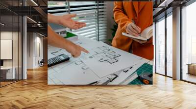 An architect and engineer work as a team, an engineer is discussing with coworker about detail of house model compare with blueprint to make sure it's exactly the same Wall mural