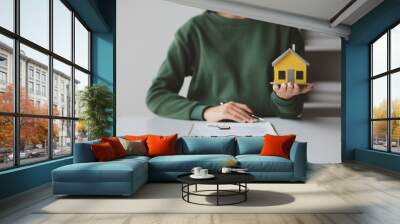 The salesperson of the housing estate in the project is preparing and verifying the contract of sale for the customer who will enter the contract. Concept of selling housing estates and real estate. Wall mural