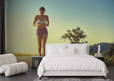 Running woman at sunrise or sunset Wall mural