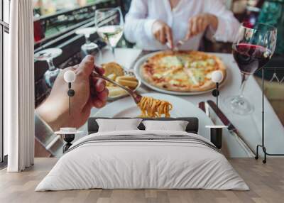 couple eating in restaurant pasta and pizza drinking wine Wall mural