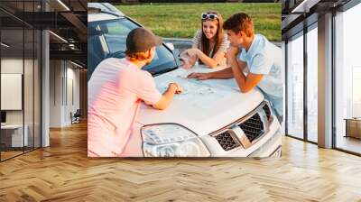 friends planning travel destination at car hood Wall mural