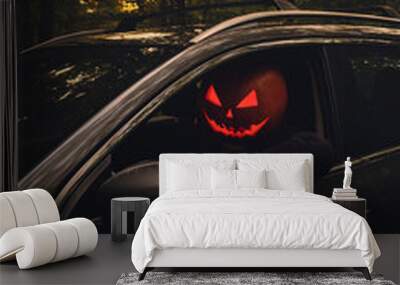 halloween concept man with pumpkin head in suv car Wall mural