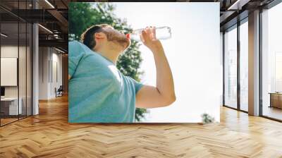 man drinking water in hot summer day. copy space Wall mural