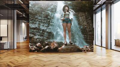 woman in brown hat enjoying view of waterfall Wall mural