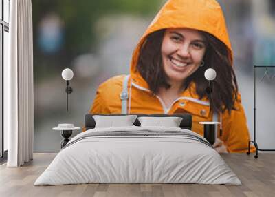 young pretty smiling woman portrait in raincoat with hood Wall mural