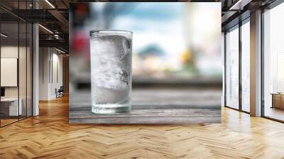 a glass of water placed on a wooden table Wall mural