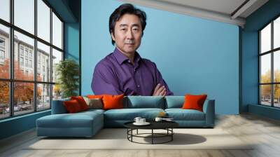 A professional photo of an Asian man with his arms crossed, wearing a purple shirt on a light blue background, in a studio shot, a portrait photograph, with soft lighting, creating soft shadows Wall mural