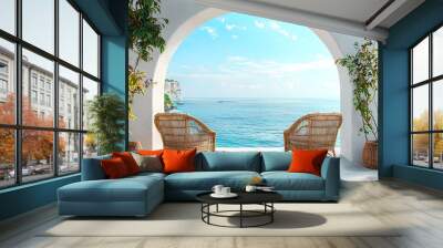 Two Wicker Chairs Facing Ocean View Through Archway Wall mural