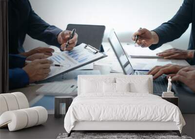 A professional business team meeting in formal suits, working at desks with financial papers, calculators, and laptops. Close-up of hands. Discussion on revenue, brand, sales, agenda, capital Wall mural