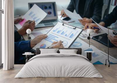 A professional business team meeting in formal suits, working at desks with financial papers, calculators, and laptops. Close-up of hands. Discussion on revenue, brand, sales, agenda, capital Wall mural