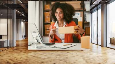 African American business woman working at warehouse preparing SME package box for delivery at small business home office. Wall mural