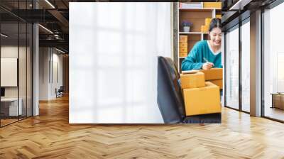 Portrait of Starting small businesses SME owners female entrepreneurs working, box and check online orders to prepare to pack the boxes, sell to customers, sme business ideas online. Wall mural