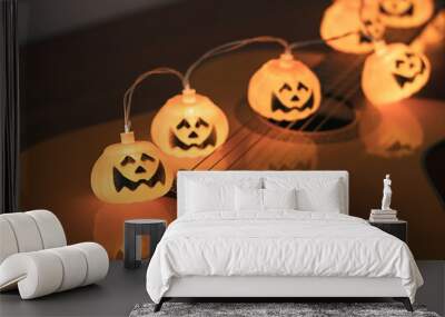 halloween pumpkin string lights glowing  on acoustic guitar. Halloween party concept. Wall mural