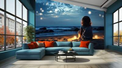 A cute little girl on the beach looking up at the stars at night Wall mural