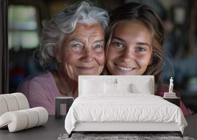 A smiling young girl is hugging an elderly woman Wall mural