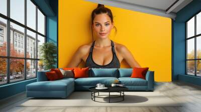 Close up fitness woman. Solid yellow studio background Wall mural