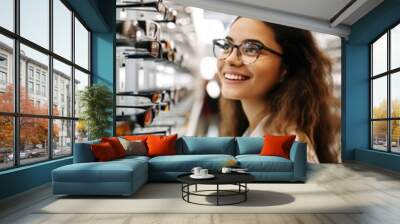 Female customer selecting optical eyewear while visiting shop Wall mural