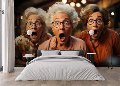 Funny portrait of three elderly shocked women looking at camera keeping mouth open Wall mural