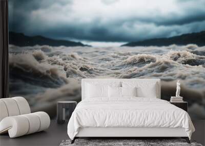 Powerful river rapids surge under a stormy sky, the water moving aggressively and foaming as it rushes forward. Wall mural