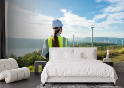 Engineer looks at wind turbine in the field. Maintenance of wind generator. Green renewable energy Wall mural