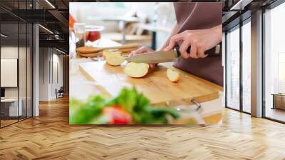 Closeup hands of asian women using knife to cutting slices apple on cutting board to preparing fruits and fresh vegetables of ingredient for cooking breakfast meal while making healthy food lifestyle Wall mural