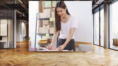 Online business concept, Asian business women packing product into parcel box and tying with rope Wall mural