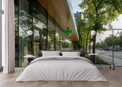 A pharmacy store with glass windows and a green cross represents contemporary lifestyle and healthcare services in an urban setting with a sunny day and treelined streets Wall mural