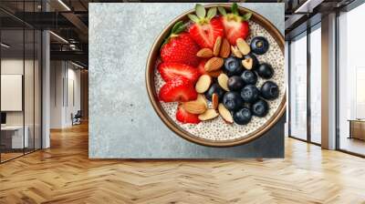 Overhead view of chia pudding in a bowl topped with fresh strawberries, blueberries, and almonds, healthy vegan breakfast concept Wall mural