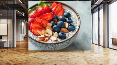 Top view of a chia pudding bowl garnished with fresh strawberries, blueberries, and sliced almonds, highlighting a nutritious and healthy breakfast option. Wall mural