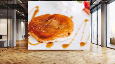 Délicieuse tarte tatin aux pommes caramélisées et sauce caramel dans une assiette blanche Wall mural