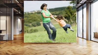 Mother is playing with her daughter in a farmer´s field Wall mural