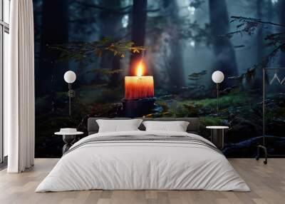 Candle burning in the dark forest. Wall mural