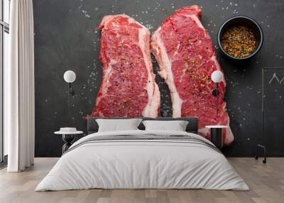 Close up of raw strip loin steaks on black cutting board with salt and spices. Wall mural