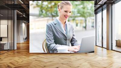 Businesswoman using laptop at cafe
 Wall mural