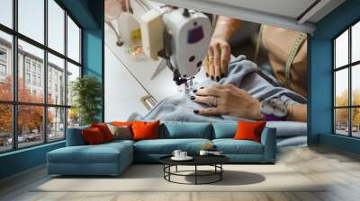 Close-up of a woman's hands sewing on the sewing machine
 Wall mural