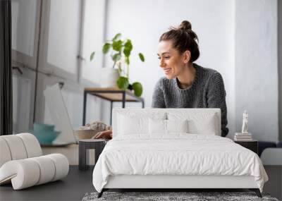 Creative young woman working on laptop in her studio
 Wall mural