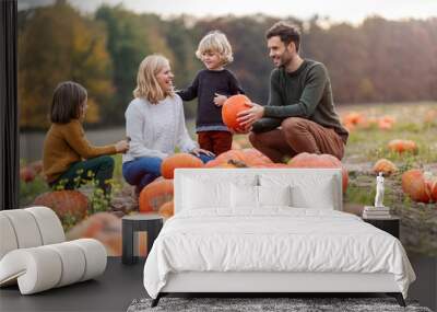 Happy young family in pumpkin patch field Wall mural